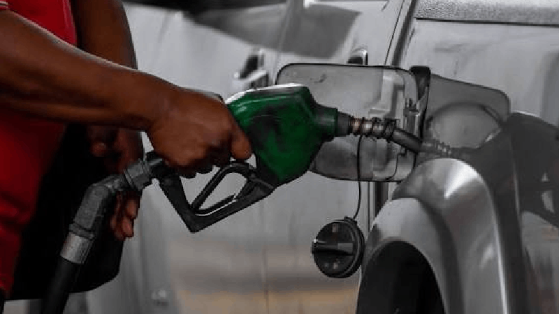 automobiliste tient le pistolet d’une pompe à essence